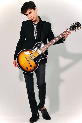 A picture of Aidan Gallagher holding guitar.